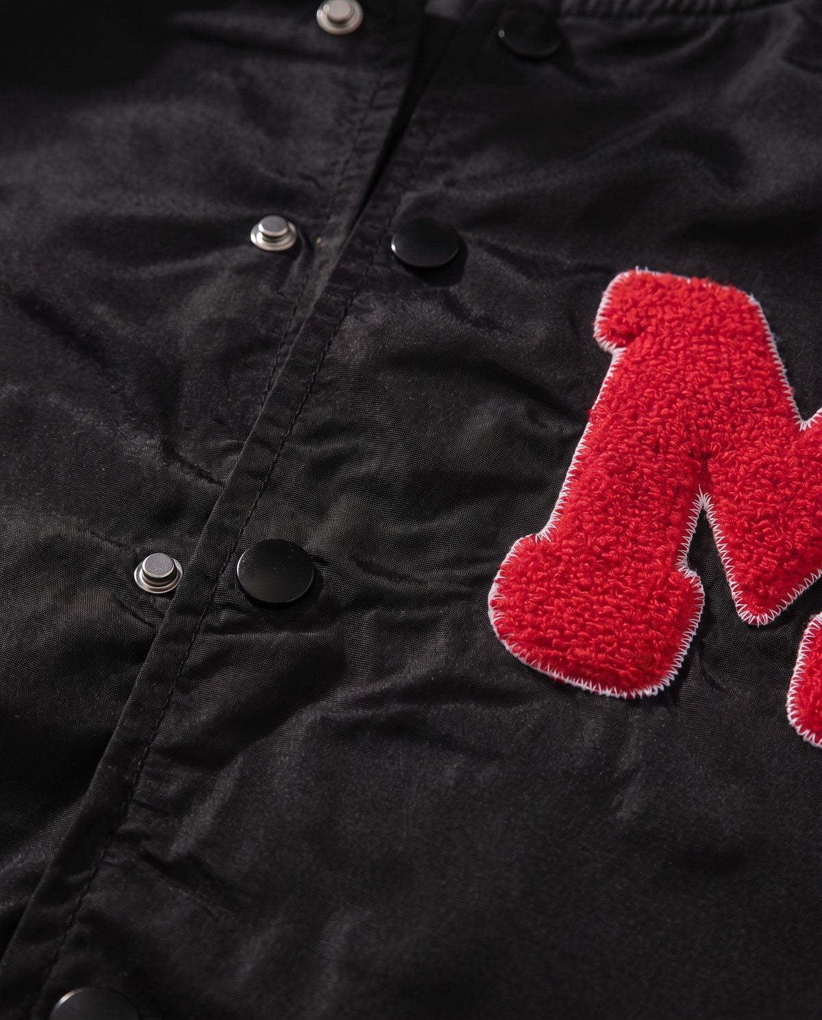 Détail des boutons pression du blouson baseball homme