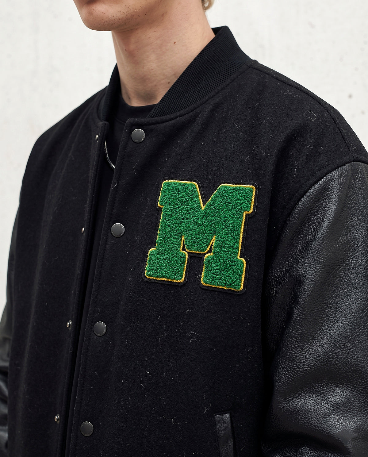 Détail lettre M chenille verte veste américaine baseball
