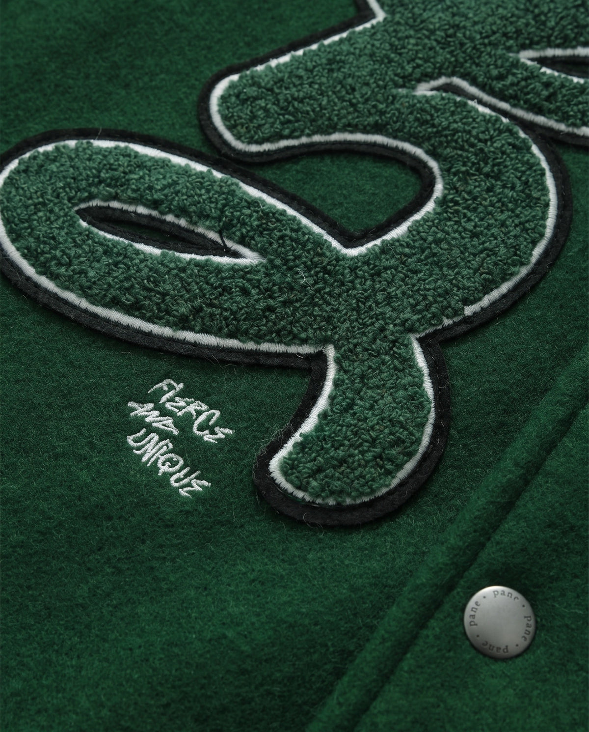 Détail de l'écusson chenille de la veste de baseball verte