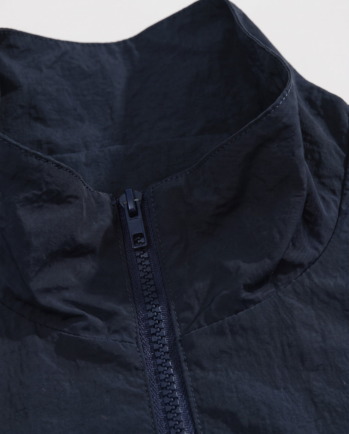 Détail du col montant zippé de la veste universitaire bleu marine