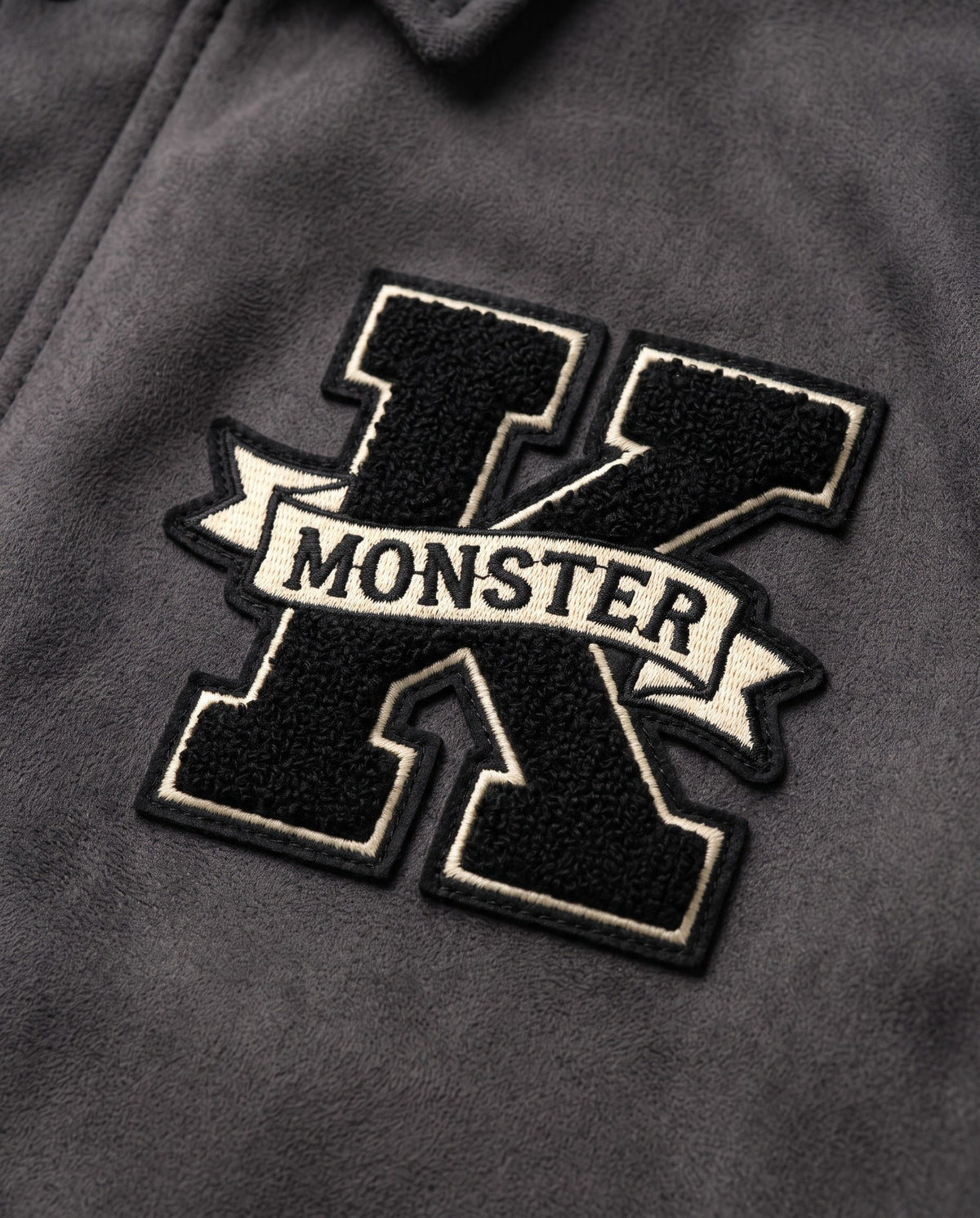 Détail de l'écusson K chenille de la veste universitaire grise