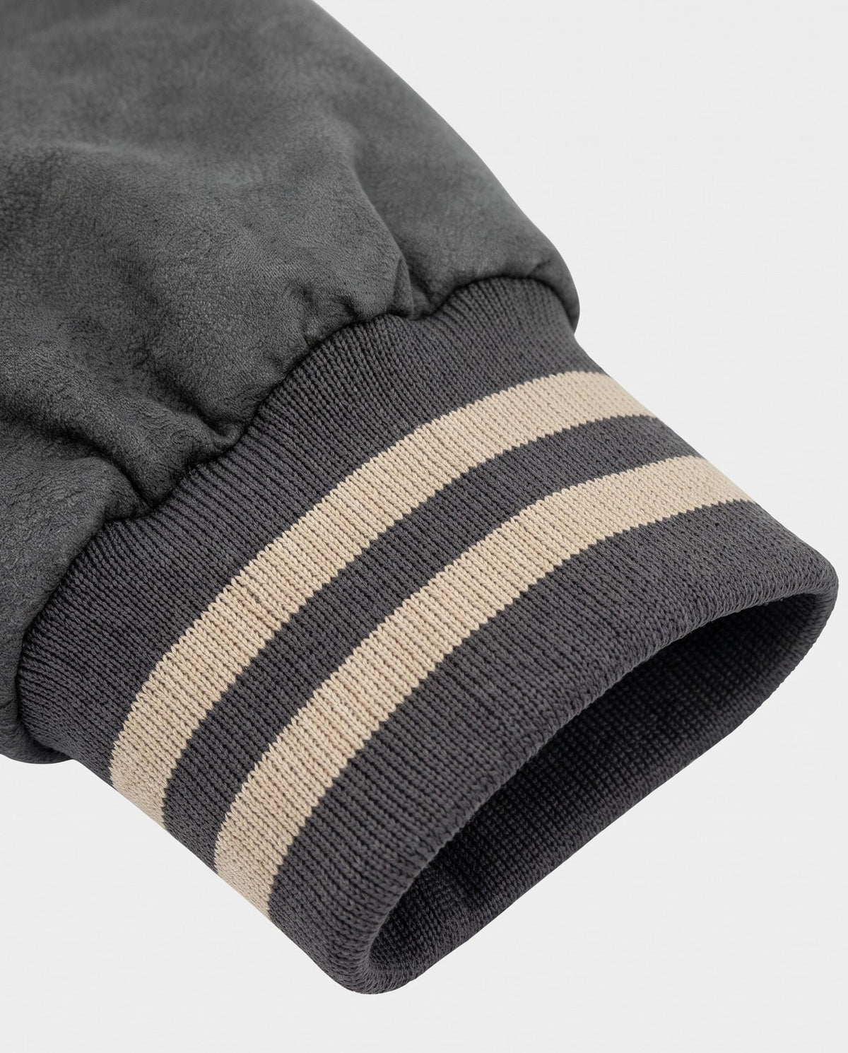 Détail du poignet rayé de la veste universitaire grise
