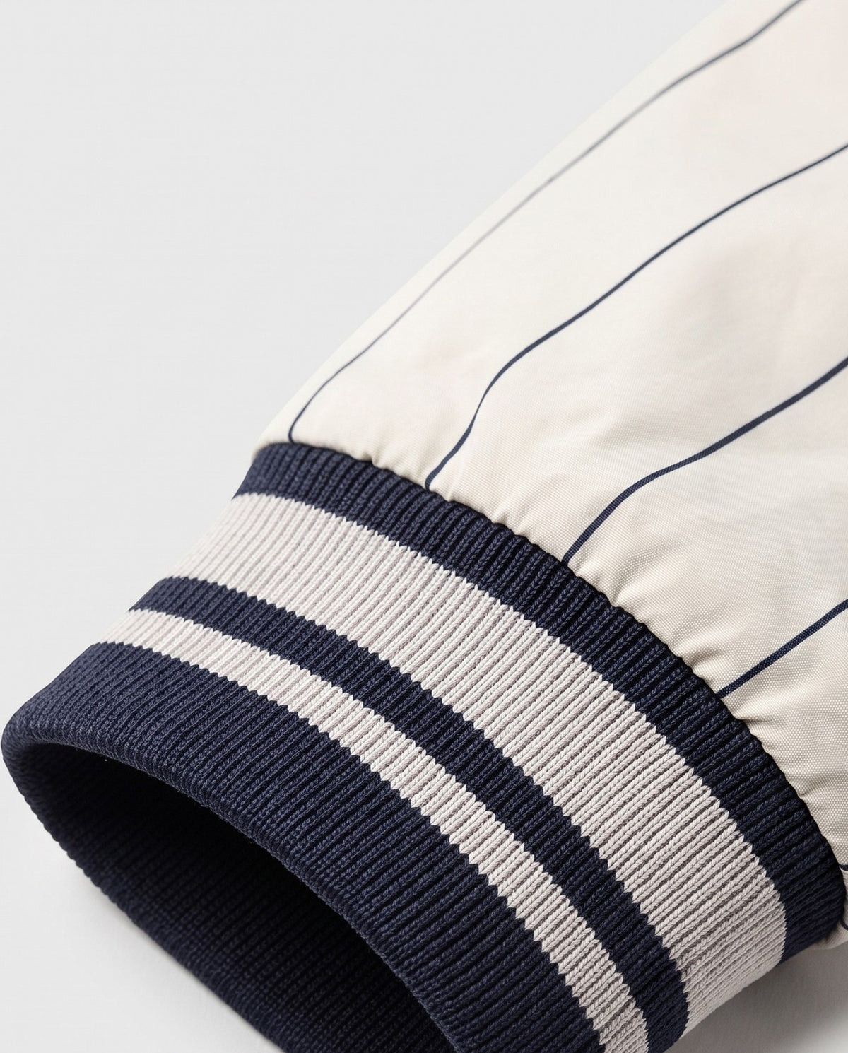 Détail du poignet rayé de la veste baseball