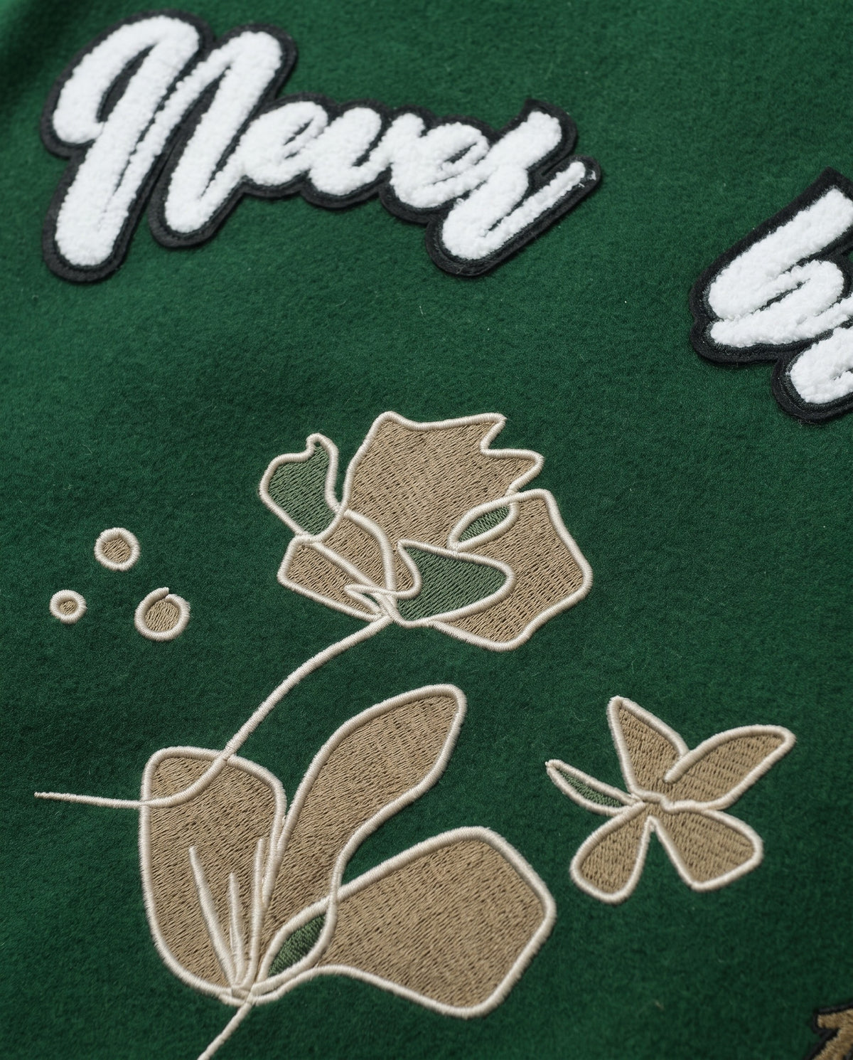 Détail de la broderie dos de la veste de baseball verte