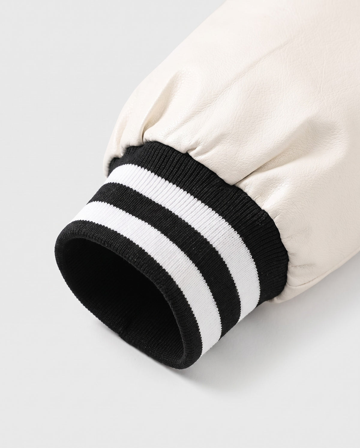 Détail du poignet côtelé rayé de la veste de baseball homme