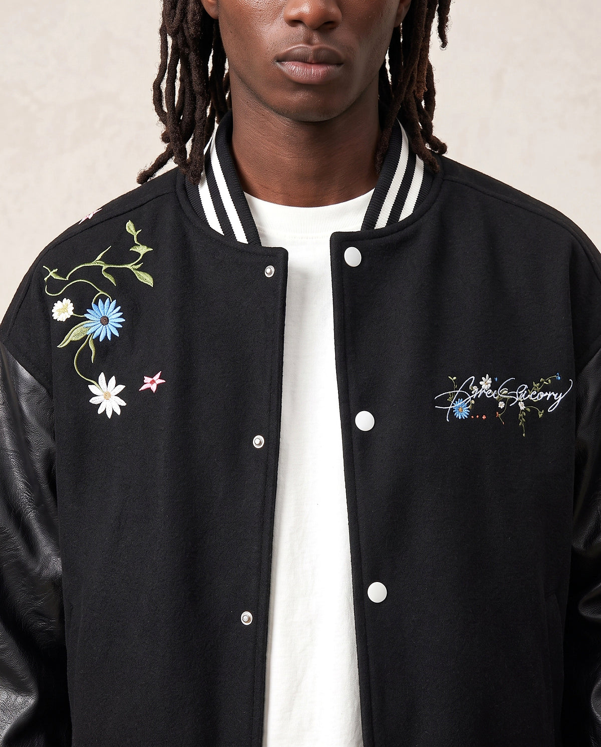 Détail broderie fleurs veste universitaire campus noire
