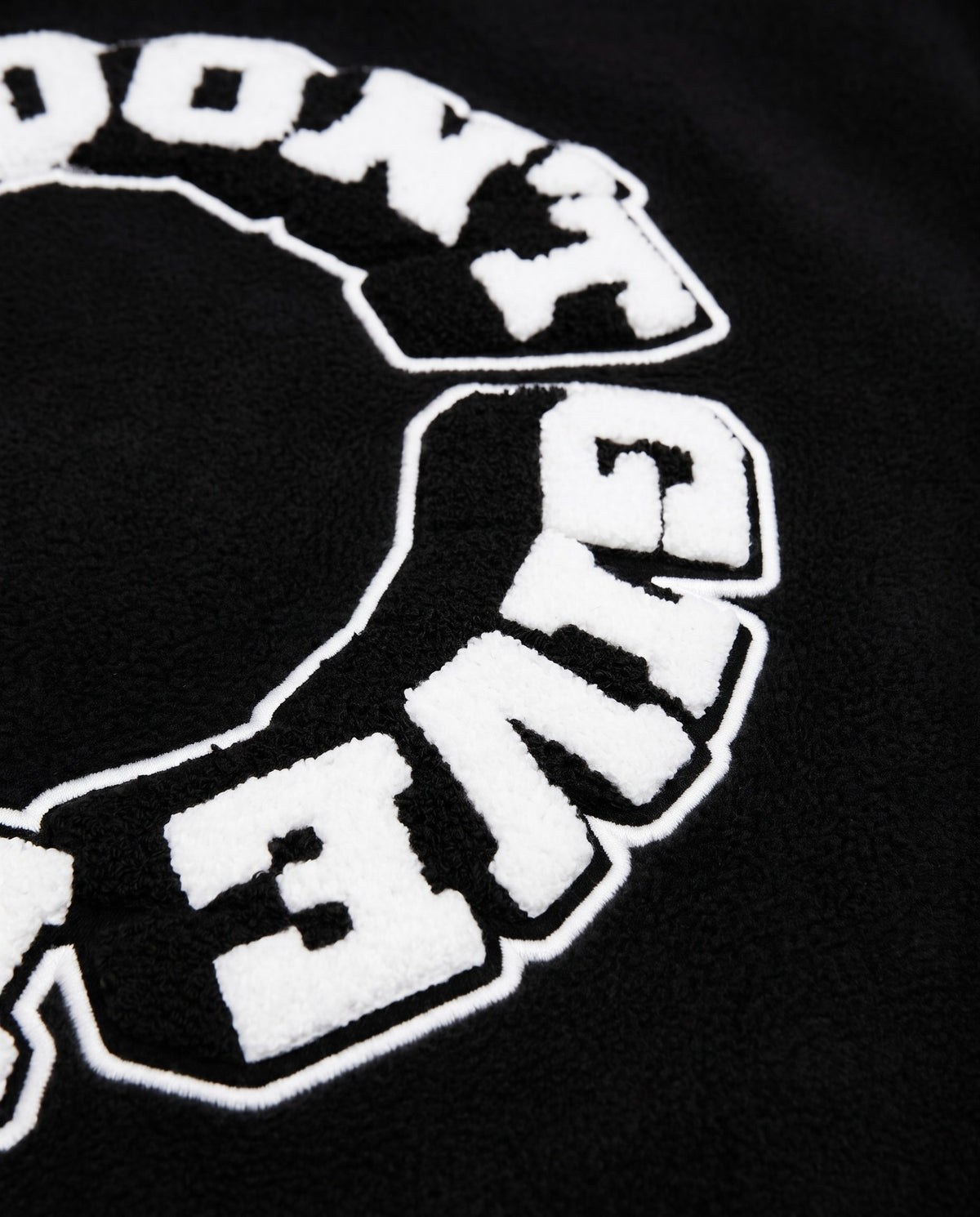 Détail du lettrage chenille dos de la varsity jacket noire
