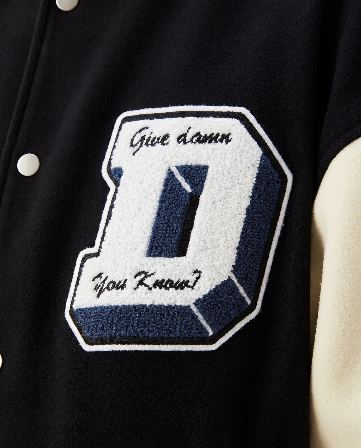 Détail de l'écusson D chenille de la varsity jacket noire
