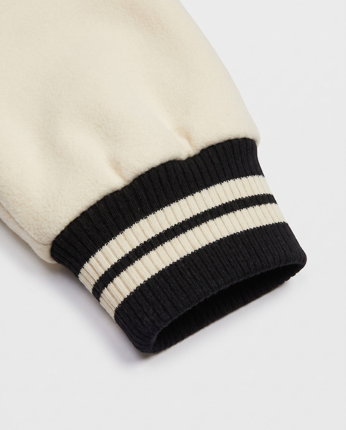 Détail du poignet rayé de la varsity jacket noire