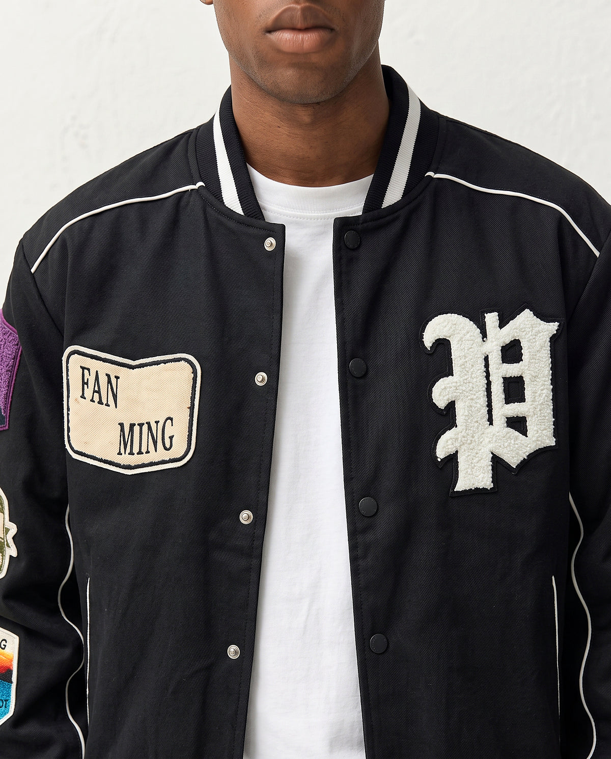 Détail lettre P et badge veste style baseball noire